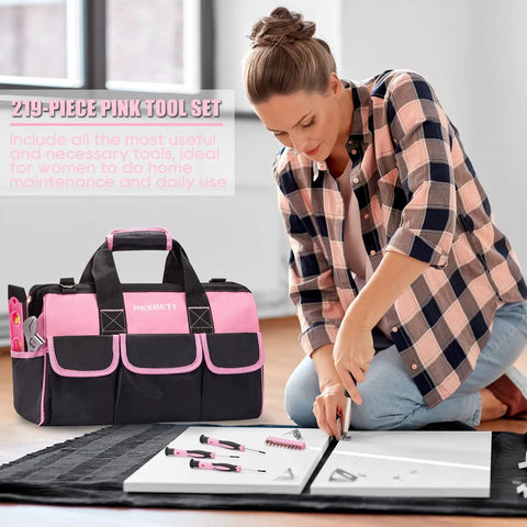 Woman using pink 219-piece tool set for women with 16 inch tool bag, ladies home repair kit visible, performing maintenance tasks.