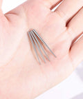 Close-up of 4 Piece Stainless Steel Piercing Taper Kit With Internal Threaded External Threaded And Push In Pin Insertion Pins held in hand