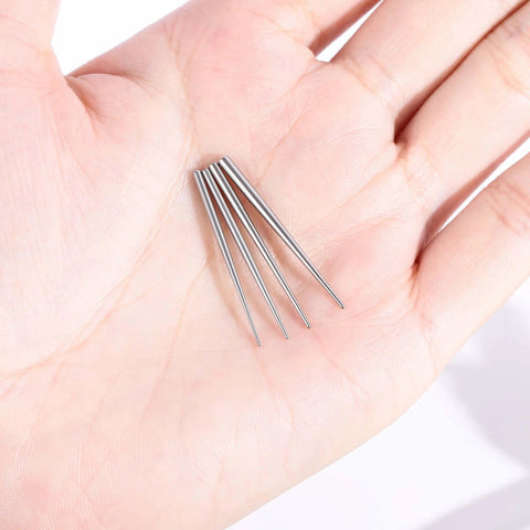 Close-up of 4 Piece Stainless Steel Piercing Taper Kit With Internal Threaded External Threaded And Push In Pin Insertion Pins held in hand