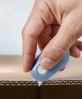 Front view of blue Slice mini box cutter with retractable ceramic blade cutting cardboard.