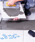 Person using Tile Leveling System Kit With 1000 Spacers One Sixteenth Inch Pro Grade Horseshoe U Shaped Clips on floor tiles