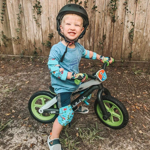 Child riding bike wearing Kid Friendly Knee And Elbow Pad Set With Pro Grade Bike Gloves For Ages 2-11 Dinosaur Design