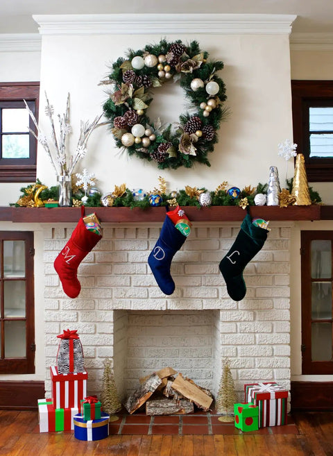 Christmas fireplace with stockings, wreath, and gifts, decorated for the holiday season.