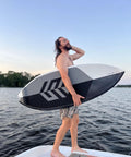 A person holding the Mondo 5 Foot 2 Inch Wakesurf Board with EVA Padding Thruster Fin Design DuraFloat Core Ultra Light Build on a boat.