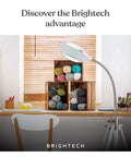 LightView Pro LED Magnifying Floor Lamp with Full Page Glass Lens in a cozy craft room setting with yarn and workspace.