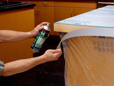 Applying Hi-Strength Spray Adhesive 90, Low VOC 14.6 oz can on countertop edge for bonding, CARB compliant, resists seepage, fast tact.