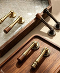Slick Eight Piece Set Of Black Solid Brass Cabinet Knobs And Drop Style Pulls For Kitchen Drawers And Cupboards With Dang Tough Screw Mount Hardware That Brings Badass Retro Charm To Your Home, showing brass and black handles on wood tray.