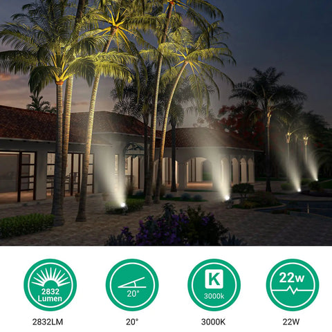 Outdoor scene with 22W Dusk To Dawn Outdoor Spotlight With Photocell Sensor illuminating palm trees in warm white 3000K light.