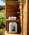No Sweat 12 Gallon Heavy Duty Portable Hand Washing Station With Reliable Manual Pump And Drain Hose next to wooden structure.