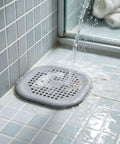 ACDANC 2 Pack Drain Cover Hair Catcher Pad, Silicone Tube Trap on tiled shower floor with water flowing over it.