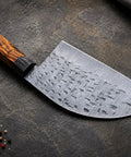 Damascus Steel Chef Knife With 7 Inch Blade And Full Tang on textured surface, showing intricate blade pattern and ergonomic handle