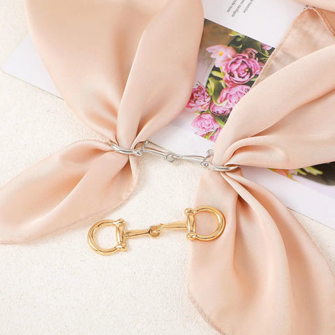 Two Piece Horse Bit Buckle Set Silk Scarf Buckle Ring displayed on peach silk scarf with gold and silver buckles
