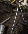 Close-up of large eye bent tapestry needle from 22 Piece Aluminum Cable Needles And Stitch Holders Kit with yarn.