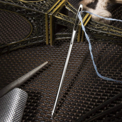 Close-up of large eye bent tapestry needle from 22 Piece Aluminum Cable Needles And Stitch Holders Kit with yarn.