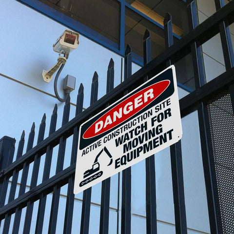 Construction Site Moving Equipment Warning Sign 8 By 12 Inches Aluminum Safety Notice attached to metal fence.