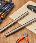 2 Pieces 1 Inch Diameter 6 Inch Long 1018 Carbon Steel Round Rods Cold Rolled Unpolished Finish with tools on wooden table