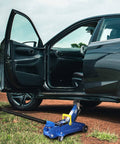 Beefed Up 2 Ton Jack Handle Replacement For Horizontal Hydraulic Pole Jack Stands, Heavy Duty Auto Tool Accessory For Quick Tire Changes, Rust Resistant Thickened Steel, High Strength Black Finish For Cars And Trucks shown lifting a car on dirt road