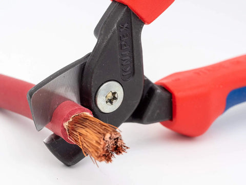 Close-up of StepCut Cable Shears 6.25 Inch With Insulated Grips cutting copper multicore wire, red handle detail visible.