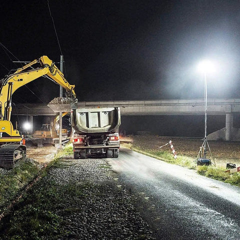 JUDYSSY Spot Lighting Led Floodlight 100W Led Outdoor Flood Lights illuminating a construction site at night with heavy machinery.