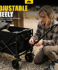 Person adjusting handle of Foldable Dog Wagon Cart With Drop-Down Tailgate, Heavy Duty All-Terrain Wheels, in outdoor setting
