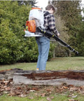 Person using Backpack Mosquito Fogger With Turbo Pump M915 Cold Fogger And Mister Duster For Outdoor Pest Control in woodlands.
