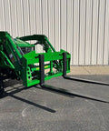 No Hassle Dual Mount Tractor Pallet Forks for Front Loader, bright green finish, attached to tractor for lifting tasks.