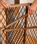Position And Lock Adjustable Wood Baby Gate for Farmhouse Style Homes, hands adjusting the tension-mount lock system