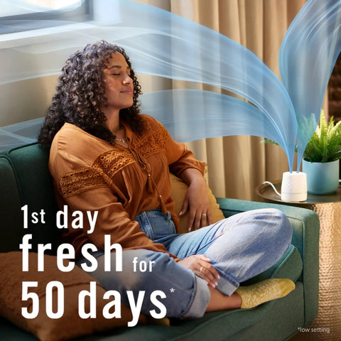 Woman relaxing in living room near Plug In Scent Booster Starter Kit With Ocean Refills, Black Oil Diffuser Air Freshener on table.