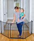 Expandable Extra Wide Baby Gate For Kids And Pets Fits 30 To 90 Inches In Black installed in doorway, with woman holding baby