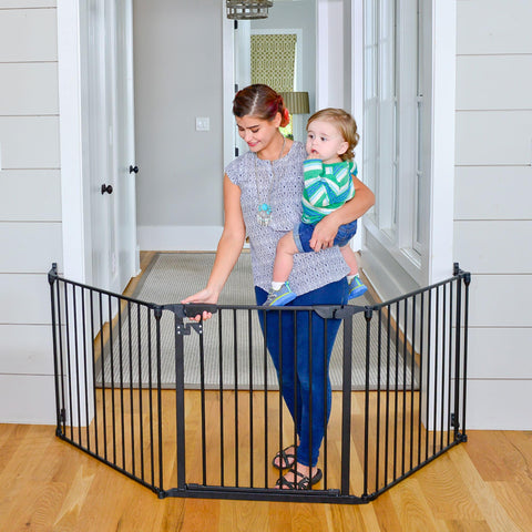 Expandable Extra Wide Baby Gate For Kids And Pets Fits 30 To 90 Inches In Black installed in doorway, with woman holding baby