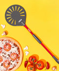 TKC 9-inch perforated aluminum pizza peel with long red handle, front view on yellow background