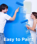 Couple painting a blue wall with rollers, showcasing teamwork and ease with the No Sweat 10.5 X 12 Inch Magnetic Wall Access Panel.