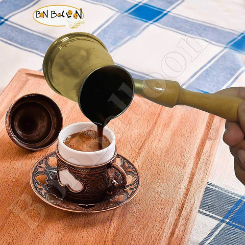 Old School Hand Hammered Solid Brass Copper Ibrik Pot Coffee Maker With Wooden Handle pouring coffee into a cup
