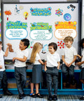 Children in front of science bulletin board set with colorful lab cutouts and scientist posters, classroom decorations.