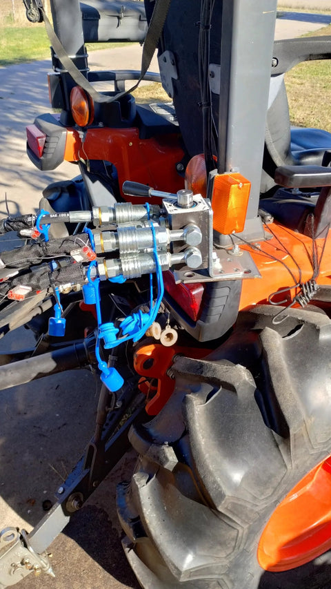 Tractor rear-mounted 6-port hydraulic diverter valve with bracket and bolts; blue hoses connected