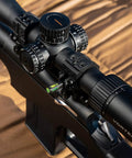 Close-up of two piece Picatinny scope rings with anti cant indicator on a rifle, showcasing flat top rings and lock nuts.
