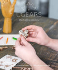 Wooden Fidget Creations Set Four Mini Mechanical Puzzles You Build Without Glue Or Tools, Stress Relief Toys For Adults And Kids, Portable Handcrafted Wood No Glue Needed Great For Focus And Calm: hands holding small wooden gear puzzle