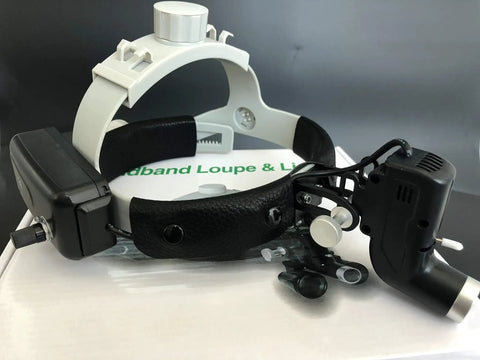 Headband loupe with adjustable light on a box, showcasing optical equipment for precision tasks.
