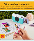 Printomatic Instant Color Photo Camera With 5MP Sensor And Zink 2x3 Sticky Back Paper Pocket Sized Easy To Use Point And Shoot No Fuss Great For Parties And Creative Projects Gift For Birthdays And Holidays. turquoise instant camera printing 2x3 sticky-back photos on a desk
