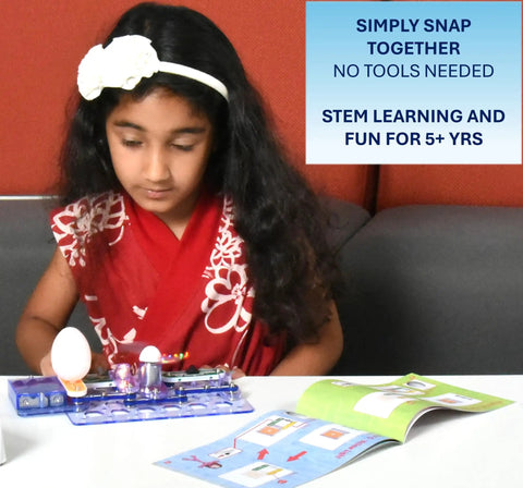 Child assembling Beginner Electronics Snap Together Kit For Kids Ages 5 To 9 STEM Exploration Project Kit To Build Real Working Circuits Safe For Young Builders Colorful Instruction Book 2016 Edition on a table.