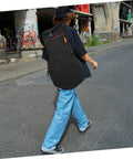Person walking with Rock Solid Oxford Fabric Drum Storage Bag Hella Durable Percussion Pouch in black, shoulder carry style.
