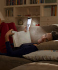 Woman using Go-To Motion Sensor LED Flashlight Night Light For Power Outages And Emergency Prep Portable Blackout Light Kit ETL Approved 3 Pack White Bright Five LED Illumination For Any Dark Room to read on couch at night.