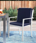 Set Of 4 Outdoor Patio Chair Cushions 20 By 17 Inch Seat Cushions With Ties, Water Resistant UV Protected All Weather Cushions For Patio Furniture, 2 Inch Thick shown on a white chair on a patio.