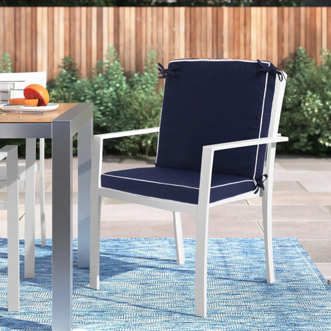 Set Of 4 Outdoor Patio Chair Cushions 20 By 17 Inch Seat Cushions With Ties, Water Resistant UV Protected All Weather Cushions For Patio Furniture, 2 Inch Thick shown on a white chair on a patio.