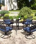 Outdoor Swivel Chairs Set Of 2 With Blue Cushions - Wrought Iron Patio Dining Chairs around a black steel table in a garden setting