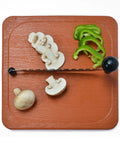 Anjali Fantastique Deluxe stainless steel vegetable cutter on wooden board; serrated blade, black knob.
