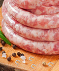 Freshly made sausages stacked on a wooden board with Bulk 4000 Piece Aluminum U Shaped Sausage Casing Clips And Nail Clippers For Rapid Batch Production Fast Changeover Tools.