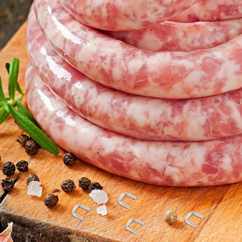 Freshly made sausages stacked on a wooden board with Bulk 4000 Piece Aluminum U Shaped Sausage Casing Clips And Nail Clippers For Rapid Batch Production Fast Changeover Tools.