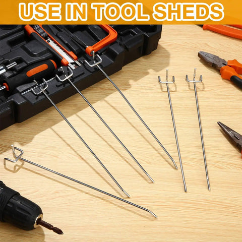 100 Pack Stainless Steel Pegboard Hooks For One Eighth And One Quarter Inch Pegboards, laid out near tools on wooden surface.