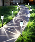 Solar Pathway Lights 10 Pack Outdoor Waterproof LED Stainless Steel Stakes illuminating a garden walkway at night.